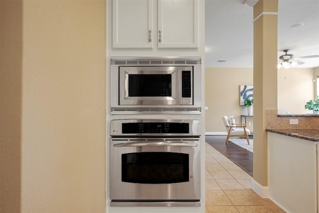 3126 Fiorellino Pl, Cedar Park, TX 78613 - kitchen with appliances with stainless steel finishes, light tile patterned floors, dark stone countertops, ceiling fan, and white cabinetry