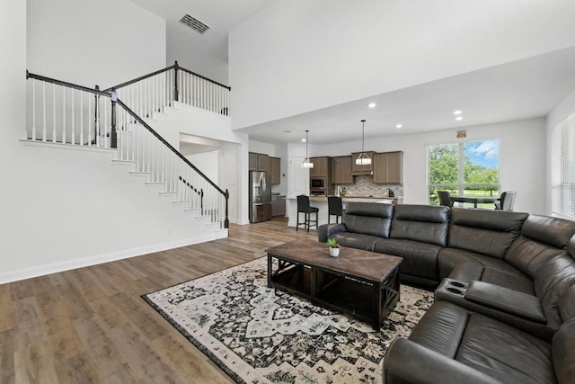 216 Tovas Secret Cv, Georgetown, TX 78628 - living room with wood finished floors, stairs, recessed lighting, and a high ceiling