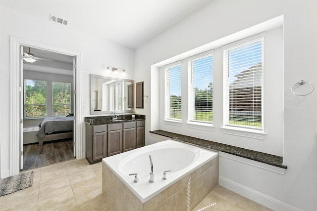 216 Tovas Secret Cv, Georgetown, TX 78628 - ensuite bathroom with a garden tub, healthy amount of natural light, vanity, and tile patterned floors