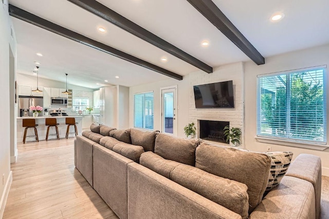 3013 Val Dr, Austin, TX 78723 - living area featuring plenty of natural light, light wood-style flooring, recessed lighting, beamed ceiling, and a brick fireplace