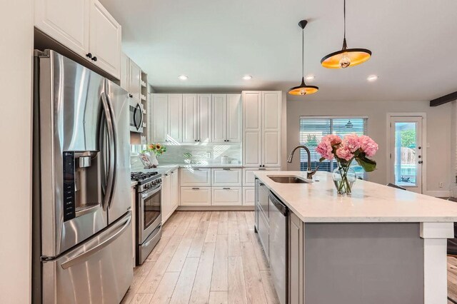 3013 Val Dr, Austin, TX 78723 - kitchen with appliances with stainless steel finishes, light wood-type flooring, white cabinetry, recessed lighting, and pendant lighting