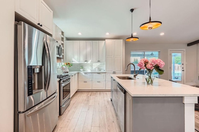 3013 Val Dr, Austin, TX 78723 - kitchen with appliances with stainless steel finishes, light wood finished floors, white cabinetry, recessed lighting, and decorative light fixtures