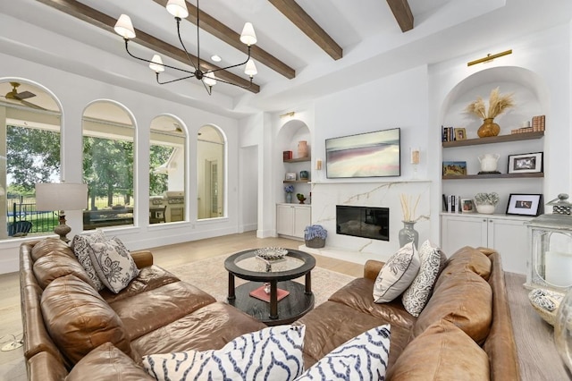 2314 Camino Del Verdes Pl, Round Rock, TX 78681 - living area featuring a chandelier, beamed ceiling, wood finished floors, a premium fireplace, and built in features