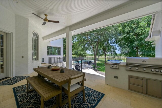 2314 Camino Del Verdes Pl, Round Rock, TX 78681 - fenced backyard with ceiling fan, a patio area, outdoor dining space, and exterior kitchen