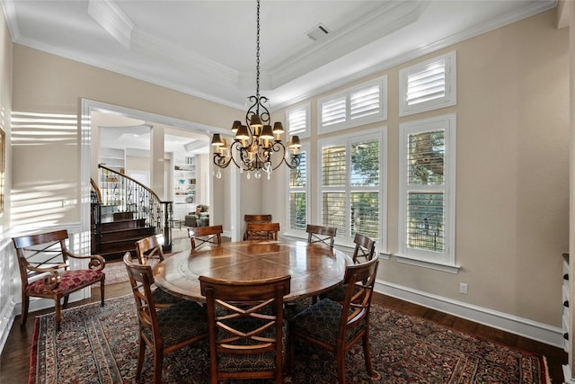 604 Flamingo Cv, Lakeway, TX 78734 - dining room featuring a chandelier, dark wood-type flooring, stairs, crown molding, and a tray ceiling