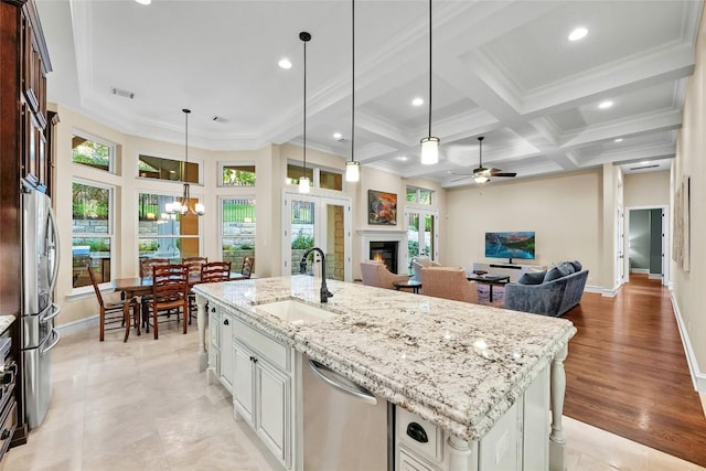 604 Flamingo Cv, Lakeway, TX 78734 - kitchen featuring stainless steel appliances, a lit fireplace, a chandelier, open floor plan, and coffered ceiling