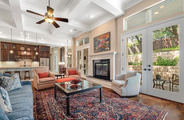 604 Flamingo Cv, Lakeway, TX 78734 - living area with french doors, a ceiling fan, coffered ceiling, a glass covered fireplace, and dark wood-type flooring