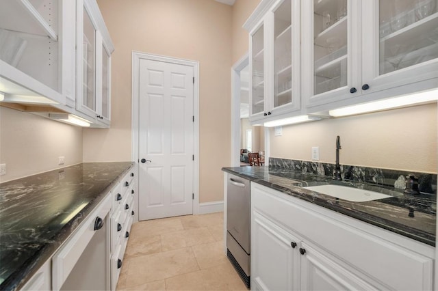 604 Flamingo Cv, Lakeway, TX 78734 - kitchen featuring white cabinetry, glass insert cabinets, stainless steel dishwasher, dark stone countertops, and light tile patterned floors