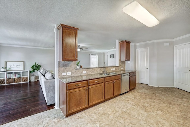 140 Housefinch Loop, Leander, TX 78641 - kitchen with ornamental molding, stainless steel dishwasher, light stone countertops, brown cabinetry, and a ceiling fan