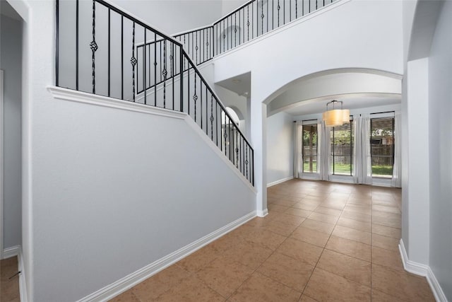 3443 Cortes Pl, Round Rock, TX 78665 - entryway featuring arched walkways, tile patterned floors, stairs, and a high ceiling