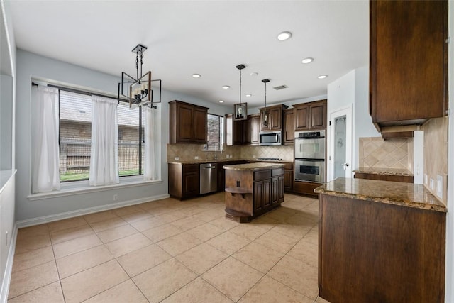 3443 Cortes Pl, Round Rock, TX 78665 - kitchen featuring stainless steel appliances, light tile patterned floors, dark stone countertops, backsplash, and recessed lighting