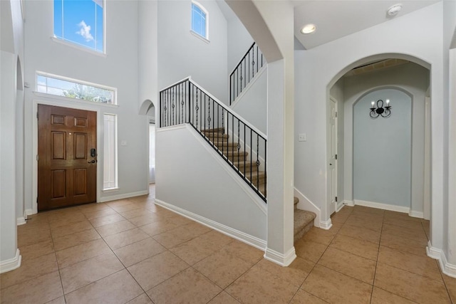 3443 Cortes Pl, Round Rock, TX 78665 - entrance foyer featuring light tile patterned floors, arched walkways, a high ceiling, and stairway