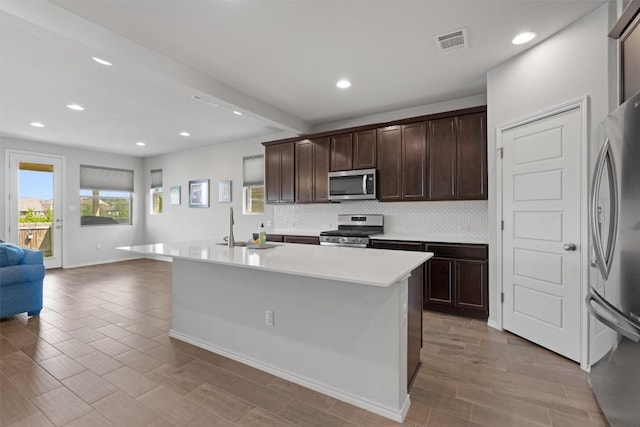 11717 Reindeer Dr, Austin, TX 78754 - kitchen featuring appliances with stainless steel finishes, backsplash, open floor plan, recessed lighting, and dark brown cabinets