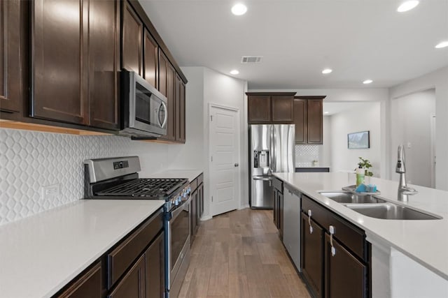 11717 Reindeer Dr, Austin, TX 78754 - kitchen with appliances with stainless steel finishes, light wood-type flooring, light countertops, dark brown cabinetry, and recessed lighting