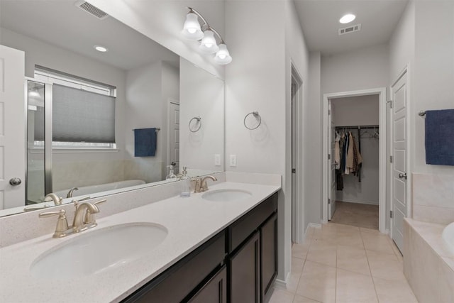 11717 Reindeer Dr, Austin, TX 78754 - bathroom with tile patterned flooring, a bath, double vanity, and a spacious closet