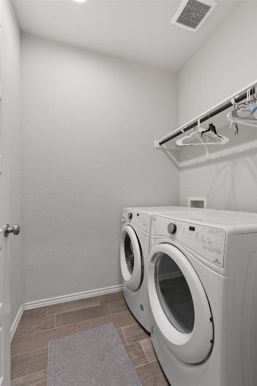 11717 Reindeer Dr, Austin, TX 78754 - washroom featuring washing machine and clothes dryer and wood tiled floors
