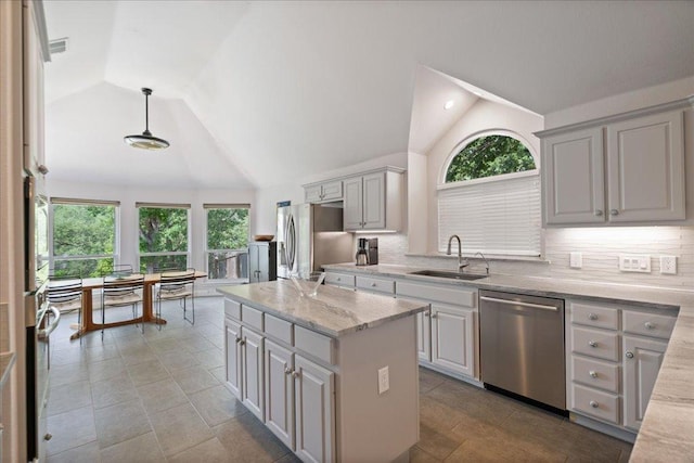 12464 Fairfax Ridge Pl, Austin, TX 78738 - kitchen with appliances with stainless steel finishes, vaulted ceiling, plenty of natural light, a kitchen island, and tasteful backsplash