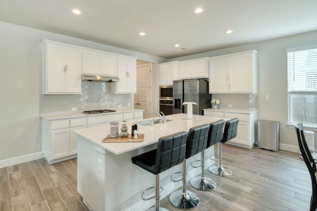 217 Stone Creek Dr, Georgetown, TX 78628 - kitchen with stainless steel appliances, light wood finished floors, recessed lighting, light countertops, and white cabinetry