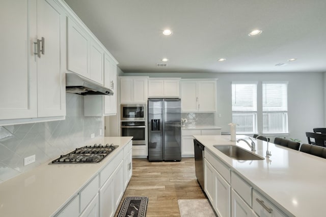 217 Stone Creek Dr, Georgetown, TX 78628 - kitchen with stainless steel appliances, under cabinet range hood, white cabinetry, light countertops, and recessed lighting