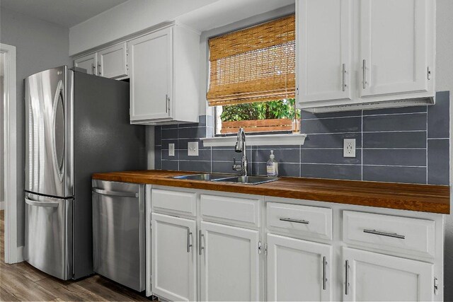 4904 Wing Rd, Austin, TX 78749 - kitchen featuring wooden counters, stainless steel appliances, backsplash, and white cabinets