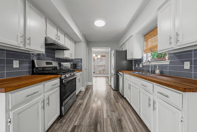 4904 Wing Rd, Austin, TX 78749 - kitchen featuring wooden counters, stainless steel appliances, under cabinet range hood, and decorative backsplash