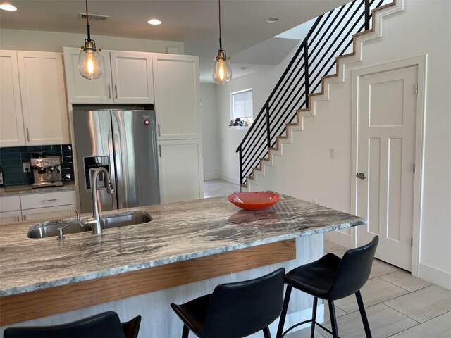 300-304 Tesla Cir, Austin, TX 78681 - kitchen featuring stainless steel fridge, a kitchen breakfast bar, white cabinets, pendant lighting, and decorative backsplash