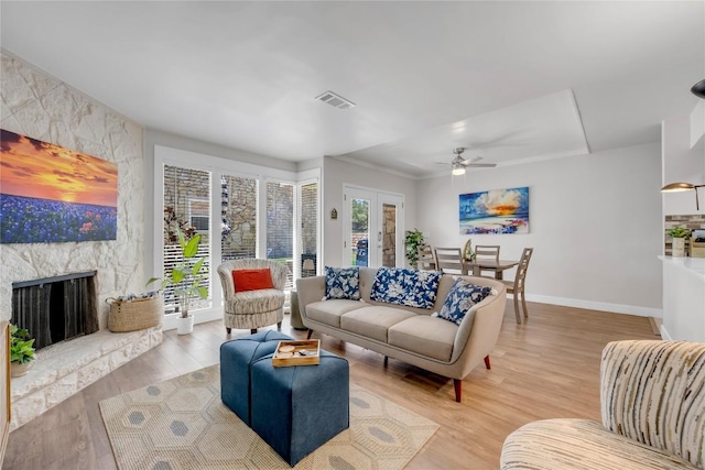 200 Free Rein Unit 5, Horseshoe Bay, TX 78657 - living room with wood finished floors, a ceiling fan, a fireplace, and french doors