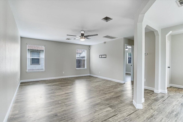 1000 Warbler Cv, Hutto, TX 78634 - spare room featuring a ceiling fan, arched walkways, and wood finished floors