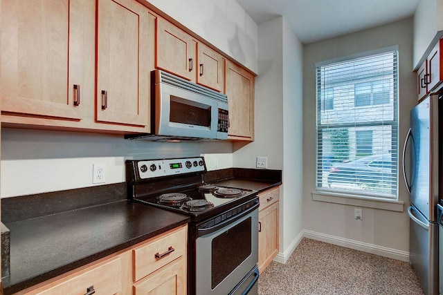 1201 Grove Blvd Unit 1404, Austin, TX 78741 - kitchen with stainless steel appliances, dark countertops, plenty of natural light, and light brown cabinets
