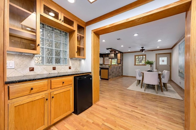 2710 Greenlawn Pkwy, Austin, TX 78757 - kitchen with ornamental molding, light wood finished floors, backsplash, ceiling fan, and glass insert cabinets
