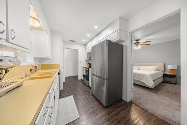2016 Wanda St, Copperas Cove, TX 76522 - kitchen featuring appliances with stainless steel finishes, dark wood-type flooring, ceiling fan, white cabinets, and recessed lighting