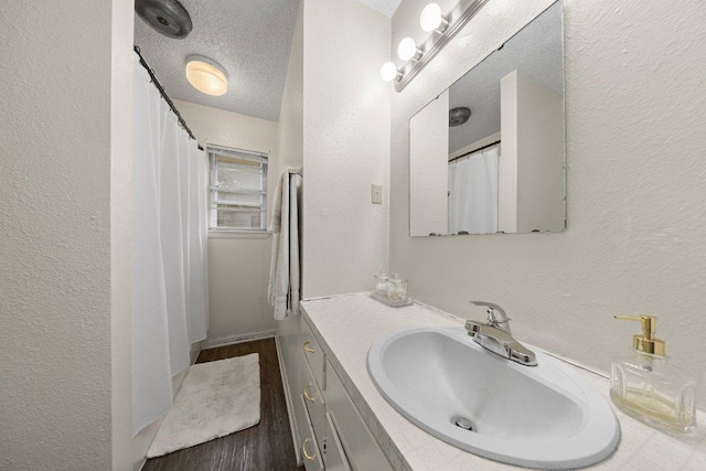 2016 Wanda St, Copperas Cove, TX 76522 - bathroom featuring vanity, wood finished floors, a textured ceiling, and a textured wall