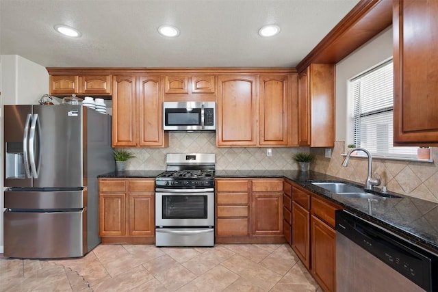 700 Canyon Bend Rd, Pflugerville, TX 78660 - kitchen with appliances with stainless steel finishes, brown cabinetry, tasteful backsplash, and recessed lighting