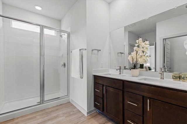 10708 Defender Trl, Austin, TX 78754 - full bath featuring wood finished floors, double vanity, and a stall shower