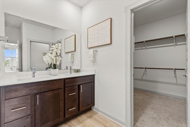 10708 Defender Trl, Austin, TX 78754 - full bath featuring double vanity, a spacious closet, and wood finished floors