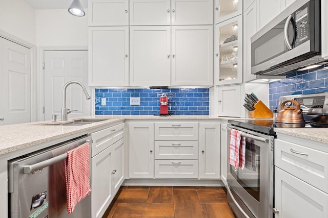 3702 Terrina St Unit 12, Austin, TX 78759 - kitchen featuring appliances with stainless steel finishes, white cabinetry, decorative backsplash, light stone countertops, and glass insert cabinets