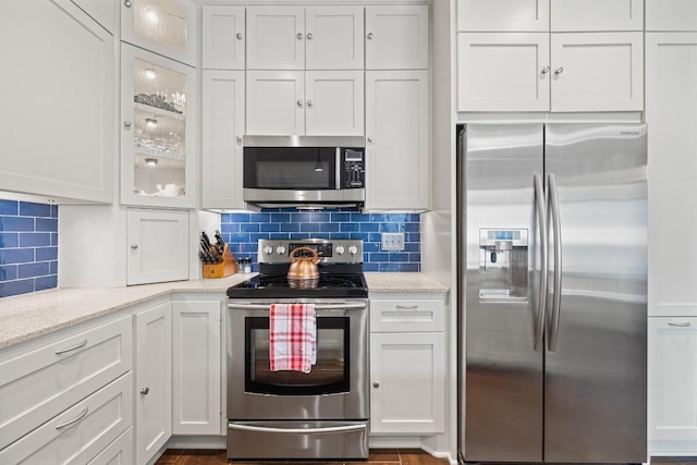 3702 Terrina St Unit 12, Austin, TX 78759 - kitchen featuring stainless steel appliances, white cabinets, and decorative backsplash