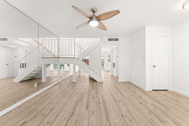 903 Silver Quail Ln, Austin, TX 78758 - unfurnished living room featuring stairway, wood finished floors, a ceiling fan, and healthy amount of natural light
