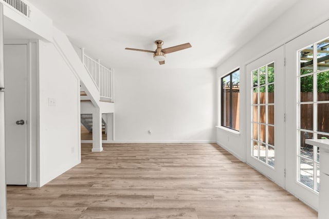 903 Silver Quail Ln, Austin, TX 78758 - unfurnished living room with a ceiling fan, light wood-style flooring, and stairs