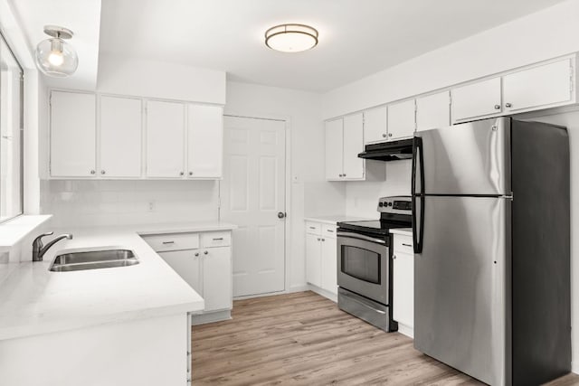 903 Silver Quail Ln, Austin, TX 78758 - kitchen with appliances with stainless steel finishes, under cabinet range hood, light countertops, white cabinetry, and decorative backsplash