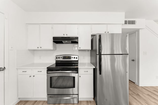 903 Silver Quail Ln, Austin, TX 78758 - kitchen featuring stainless steel appliances, extractor fan, light wood-style flooring, light countertops, and decorative backsplash