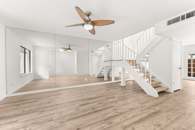 903 Silver Quail Ln, Austin, TX 78758 - unfurnished living room with ceiling fan, stairway, and wood finished floors