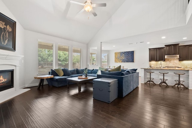 841 Expedition Way, Round Rock, TX 78665 - living room with dark wood-style flooring, a glass covered fireplace, a ceiling fan, high vaulted ceiling, and recessed lighting