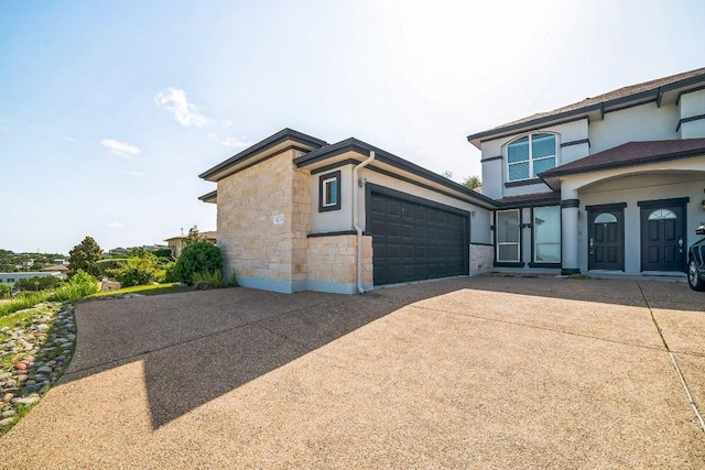 1213 Delsie Dr Unit A, Austin, TX 78734 - view of side of property featuring concrete driveway, an attached garage, stone siding, and stucco siding