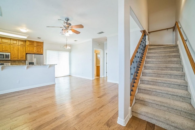 1213 Delsie Dr Unit A, Austin, TX 78734 - stairs with ceiling fan, wood finished floors, crown molding, and a chandelier