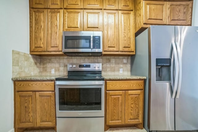 1213 Delsie Dr Unit A, Austin, TX 78734 - kitchen with stainless steel appliances, decorative backsplash, light stone countertops, and brown cabinets