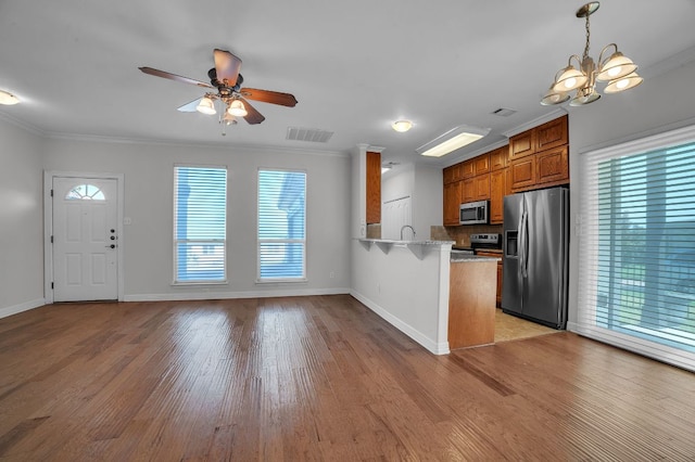 1213 Delsie Dr Unit A, Austin, TX 78734 - kitchen featuring stainless steel appliances, brown cabinets, a peninsula, plenty of natural light, and ornamental molding