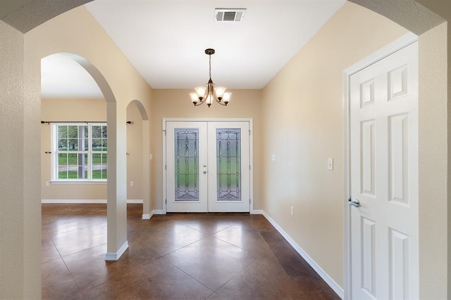 10565 N 77th Hwy, Lexington, TX 78947 - entrance foyer featuring dark tile patterned flooring, a chandelier, french doors, and arched walkways