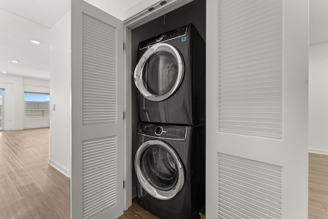 4361 S Congress Ave Unit 514, Austin, TX 78745 - laundry area with stacked washer and clothes dryer, wood finished floors, and recessed lighting