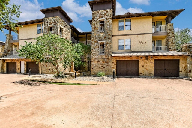 6608 Lantern View Dr Unit 102, Jonestown, TX 78645 - view of front of property with driveway, a garage, stucco siding, and a balcony